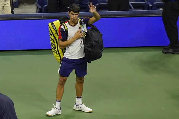 Carlos Alcaraz, of Spain, gestures to the crowd as he leaves the court after he withdrew from a match against Felix Auger-Aliassime, of Canada, during the quarterfinals of the U.S. Open tennis tournam ...