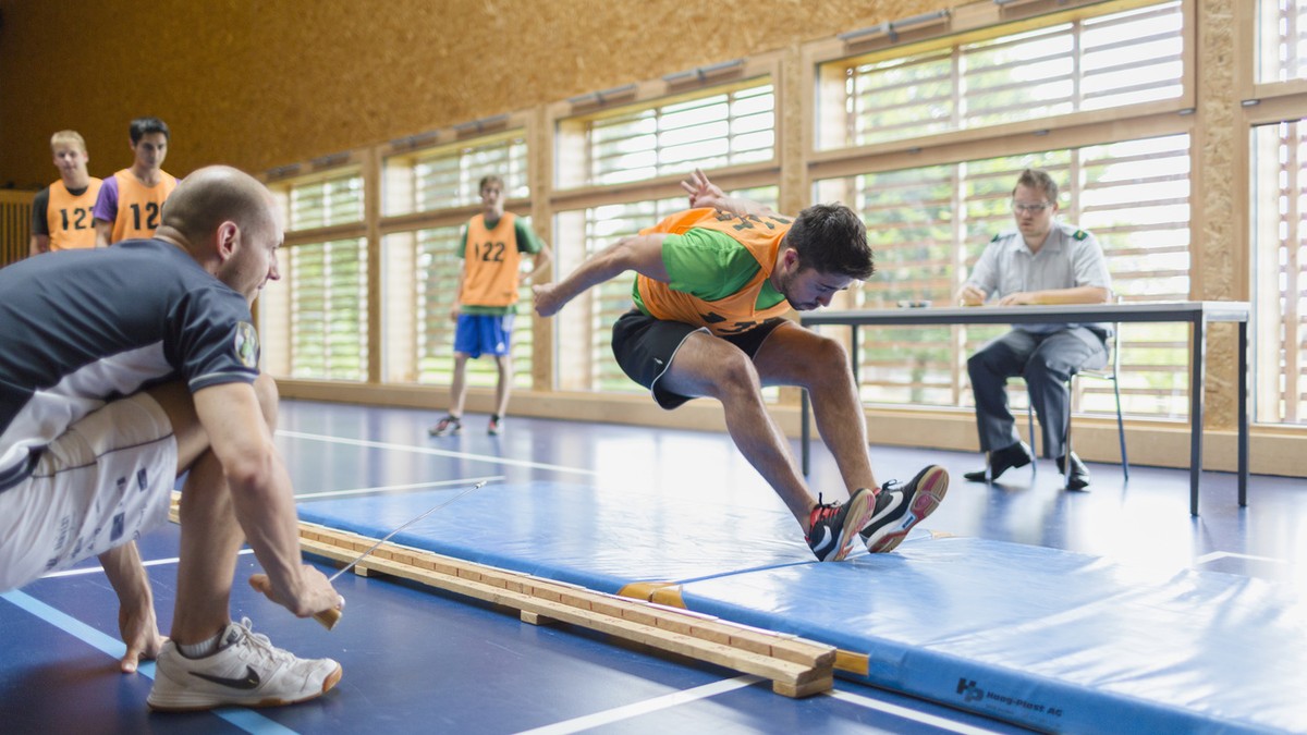 During the sports exam, a young man does the standing long jump, where he jumps from the gym floor onto a mat and where the distance between the jump line and the body's rearmost point of contact ...