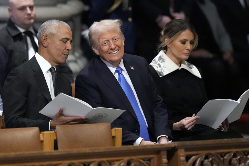 Former President Barack Obama talks with President-elect Donald Trump, next to Melania Trump, as they arrive to attend the state funeral for former President Jimmy Carter at Washington National Cathed ...