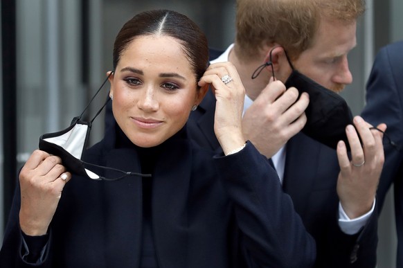 epa09620994 YEARENDER 2021 FACES OF THE YEAR..Britain&#039;s Meghan, Duchess of Sussex (L) and Prince Harry, Duke of Sussex remove their protective face masks before posing for photographers in front  ...