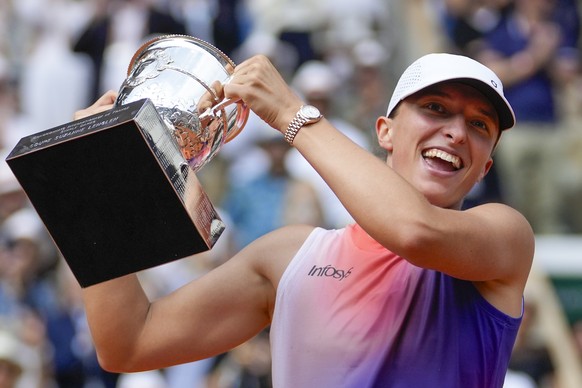 FILE - Poland&#039;s Iga Swiatek holds the trophy after winning the women&#039;s final of the French Open tennis tournament against Italy&#039;s Jasmine Paolini at the Roland Garros stadium in Paris,  ...