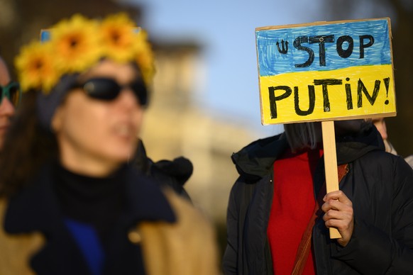 Protestors carry placards with &quot;Stop Putin&quot; as they take part in a demonstration against the Russian invasion of Ukraine on the sideline of the Financial Times Commodities Global Summit, in  ...