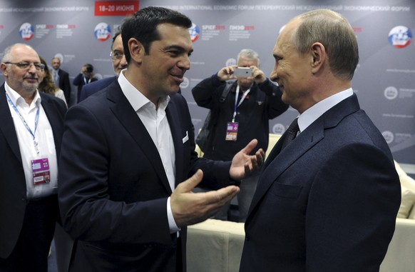 Greek Prime Minister Alexis Tsipras (L) speaks with Russian President Vladimir Putin during a session of the St. Petersburg International Economic Forum 2015 (SPIEF 2015) in St. Petersburg, Russia, Ju ...