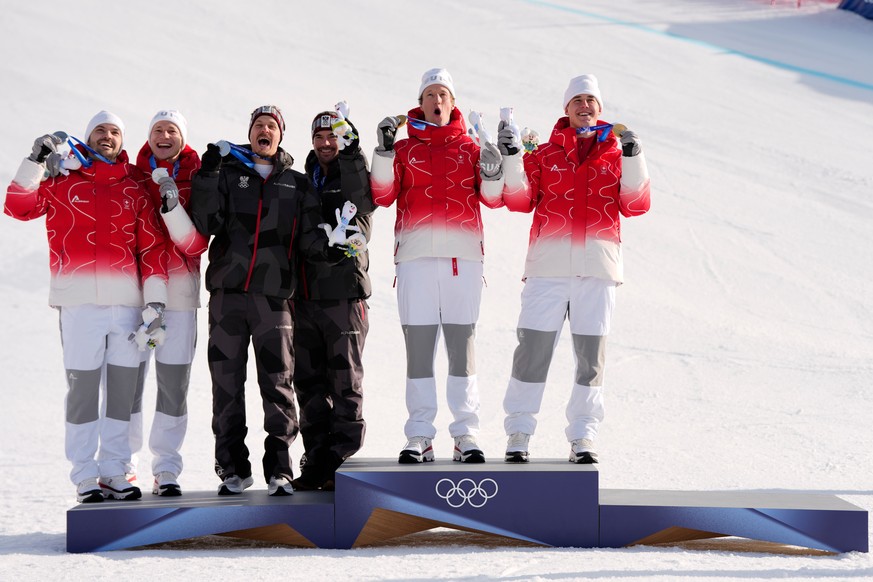 From right, gold medalists Switzerland's Franjo von Allmen, and teammate Tanguy Nef celebrate on the podium with joint-silver medalists Austria's Vincent Kriechmayr and teammate Manuel Felle ...