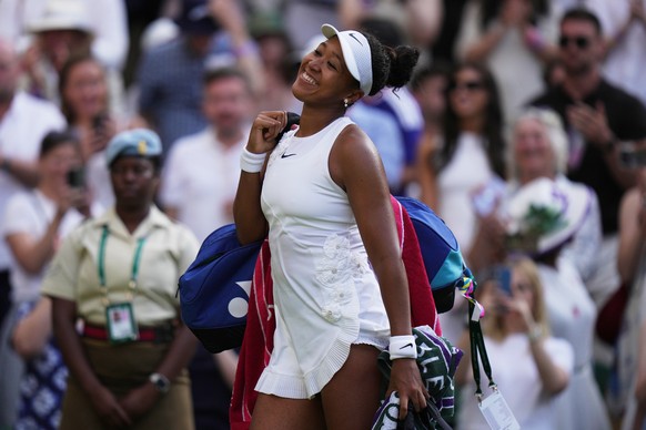 Naomi Osaka of Japan leaves the court smiling after beating Aryna Sabalenka of Belarus in their fourth round women's singles match at the Wimbledon Tennis Championships in London, Sunday, July 5, ...