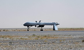 A US Predator unmanned drone armed with a missile stands on the tarmac of Kandahar military airport as Afghan President Hamid Karzai spoke at a meeting with tribal leaders in Kandahar city, Afghanistan, Sunday June 13, 2010.  President Karzai appealed to hundreds of tribal and religious leaders to support a major operation in their southern province, the heartland of a Taliban insurgency. Karzai, accompanied by top NATO commander US General Stanley McChrystal, spoke to representatives and residents in Kandahar about renewed efforts to bring stability to the war-weary province. (AP Photo//Massoud Hossaini, Pool)