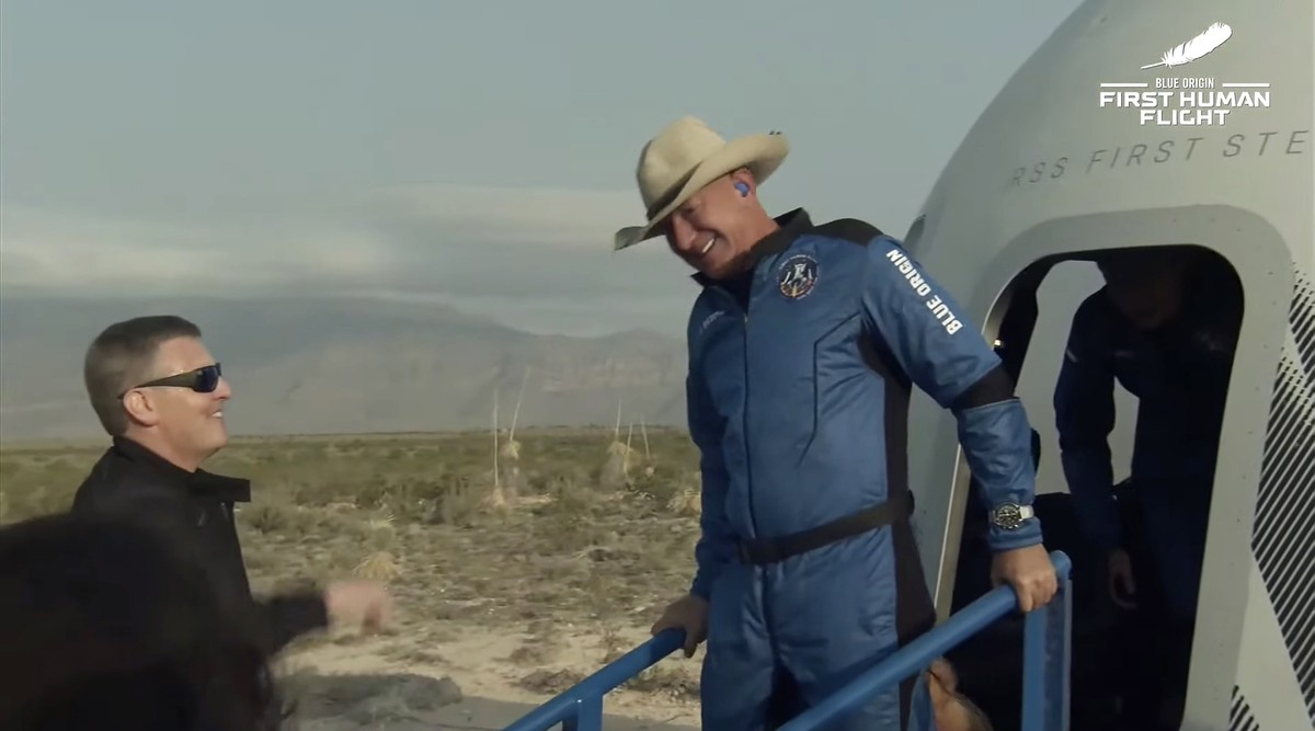 epa09355040 A handout photo made available by Blue Origin shows Jeff Bezos (R) reacting as he leaves the capsule after Blue Origin New Shepard with Jeff Bezos, Mark Bezos, Wally Funk and Oliver Daemen ...