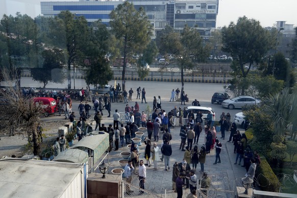 People stand outside their office building after an earthquake was felt in Islamabad, Pakistan on Thursday, January 11, 2024.  A magnitude 6.4 earthquake shook much of Pakistan and part of neighboring Af...