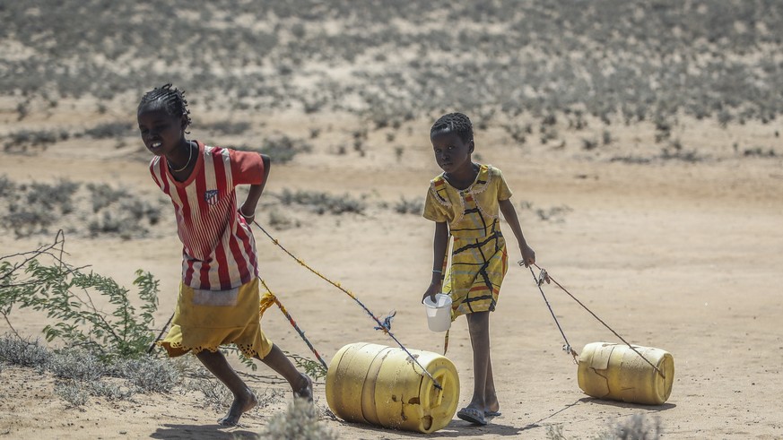 Young girls pull containers of water as they return to their huts from a well in the village of Lomoputh in northern Kenya Thursday, May 12, 2022. United Nations Under-Secretary-General for Humanitari ...