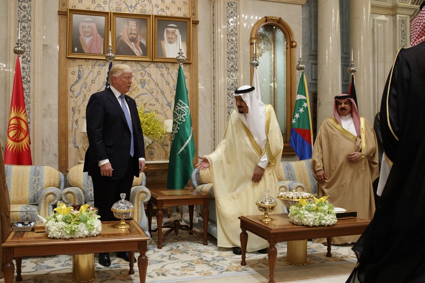 Saudi King Salman, second right, invites U.S. President Donald Trump to sit during a meeting at the Gulf Cooperation Council Summit, at the King Abdulaziz Conference Center, Sunday, May 21, 2017, in R ...