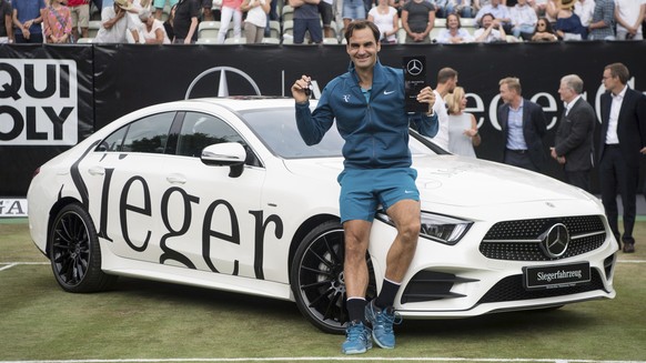 Roger Federer poses for media during the winner ceremony, after he beats Milos Raonic in the final tennis match of the ATP Mercedes Cup in Stuttgart, Sunday June 17, 2018. (Marijan Murat//dpa via AP)