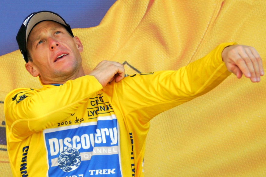 FILE - In this July 22, 2005 file photo overall leader Lance Armstrong, of Austin, Texas, pulls on the yellow jersey on the podium after the 19th stage of the Tour de France cycling race between Issoi ...