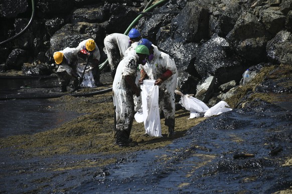 Workers from state own Heritage Petroleum Oil and Gas Company clean up an oil spill that reached Rockly Bay beach, in Scarborough, south western Tobago, Trinidad and Tobago, Sunday, Feb. 11, 2024. (AP ...