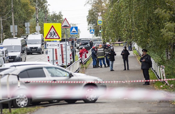 epaselect epa10207174 Russian policemen and emergency services members work near the scene of a school shooting at school 88 in Izhevsk, Russia, 26 September 2022. The shooting began during class when ...