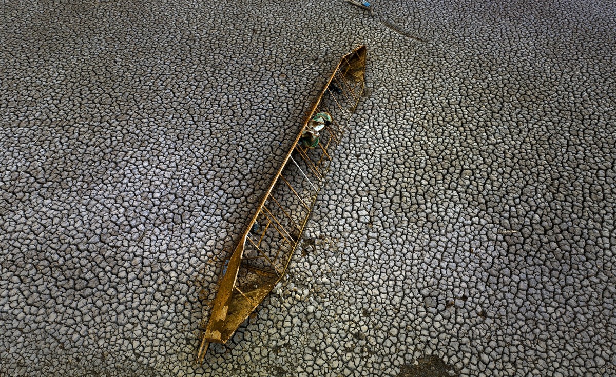 An old boat is photographed half-buried after the water level has dropped at the Sau reservoir, about 100 km (62 miles) north of Barcelona, Spain, Tuesday, April 18, 2023. Authorities in Spain's  ...