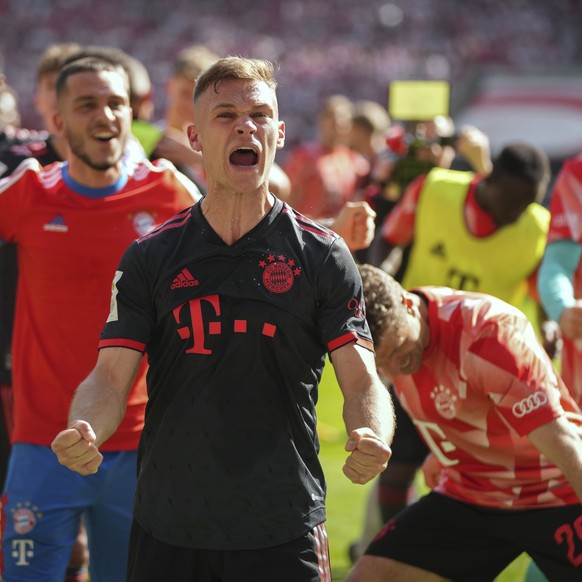 Bayern's Joshua Kimmich, centre, celebrates with teammates winning the German championship after the German Bundesliga soccer match between 1.FC Cologne and FC Bayern Munich in Cologne, Germany, ...