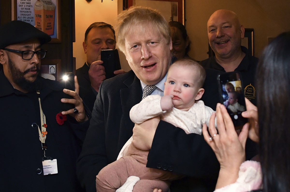 Britain' Prime Minister Boris Johnson holds a baby as he meets with supporters at the Lych Gate Tavern in Wolverhampton, England, Monday, Nov. 11, 2019 as part of the General Election campaign tr ...