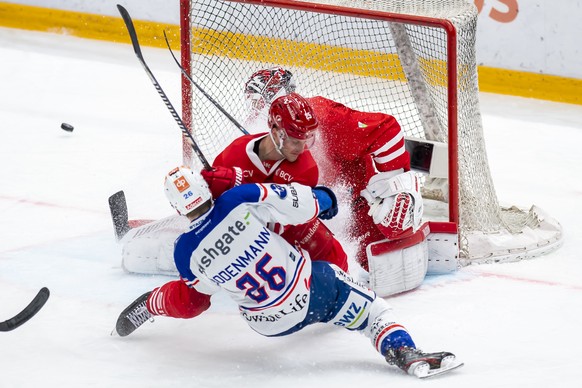 L&#039;attaquant lausannois Cory Emmerton, droite, a la lutte pour le puck avec l&#039;attaquant zuerichois Simon Bodenmann, gauche, devant le gardien lausannois Tobias Stephan, centre, lors du troisi ...