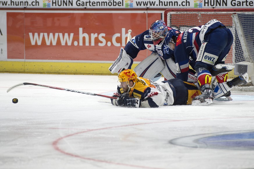 Zugs Viktor Stalberg gegen Zuerichs Torhueter Lukas Flueeler und Phil Baltisberger (r) im zweiten Eishockey Playoff-Viertelfinalspiel der National League zwischen den ZSC Lions und dem EV Zug, am Dien ...