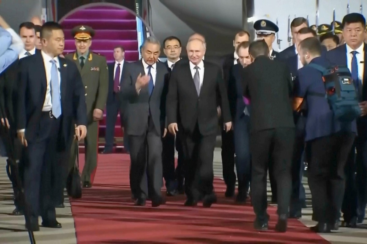 In this image taken from pool video, Russian President Vladimir Putin, center right, is escorted by China's Foreign Minister Wang Yi as he arrives in Beijing, Tuesday, May 19, 2026, fora two day  ...