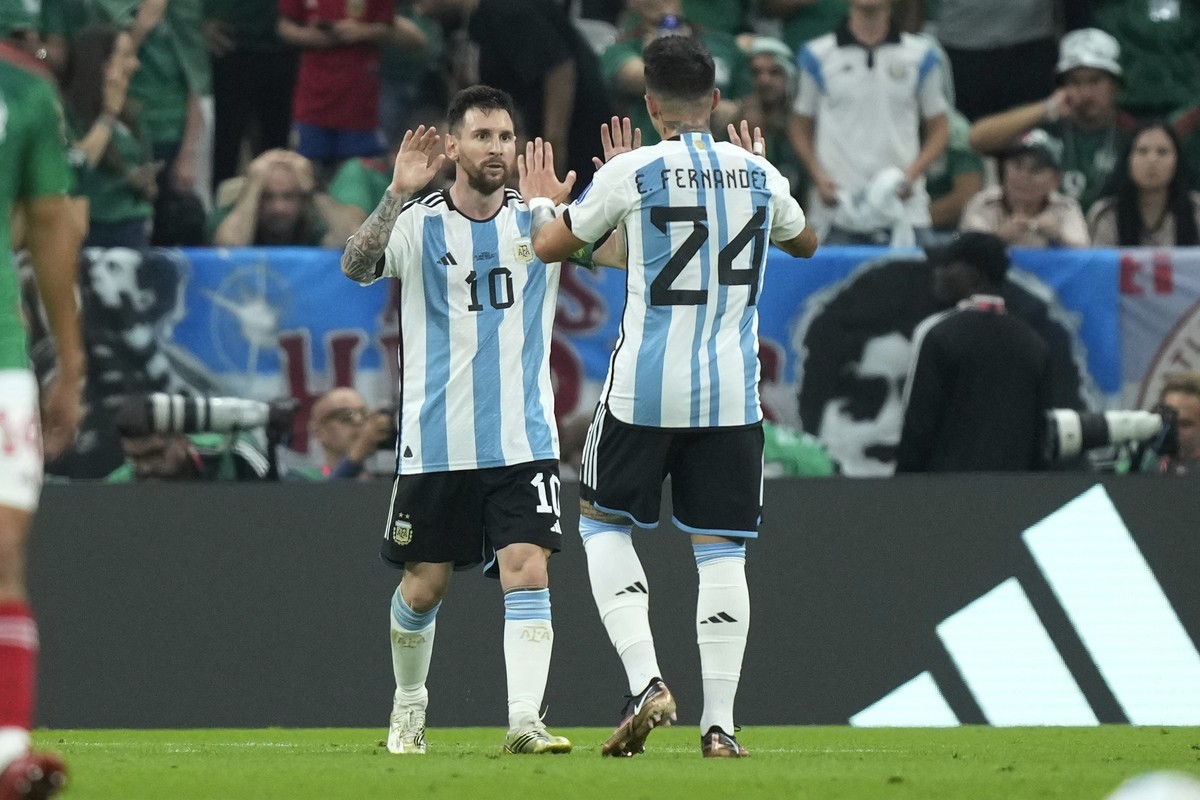 Argentina's Lionel Messi, left, celebrates with his teammate Enzo Fernandez after he scored his side's first goal during the World Cup group C soccer match between Argentina and Mexico, at t ...