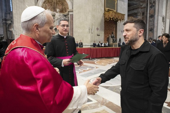 epa12113628 A handout photo made available by the Presidential Press Service shows Pope Leo XIV (L) shaking hands and talking to Ukraine&#039;s President Volodymyr Zelensky (R) after a Holy Mass for t ...