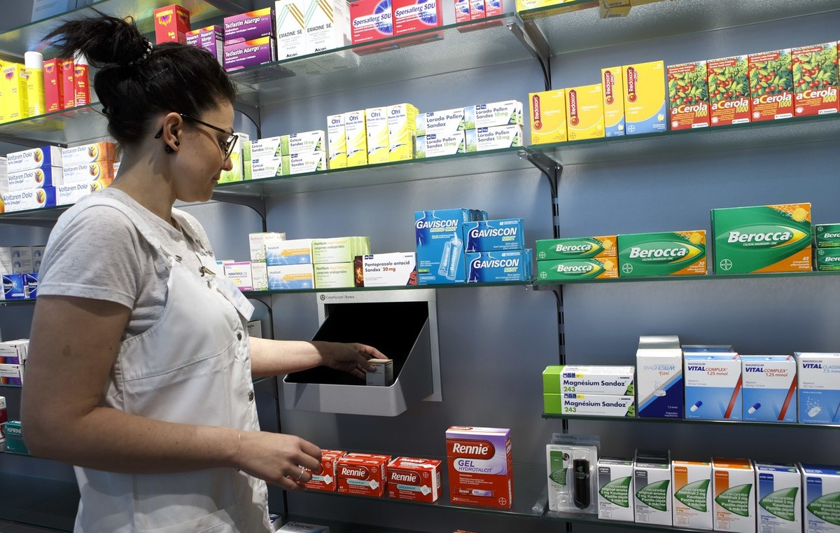 Une assistante en pharmacie de Pharma24, situee dans le batiment des HUG, prend une boite de medicament a l'une des sortie du robot distributeur de medicament, ce mardi 25 avril 2017 a Geneve. La ...
