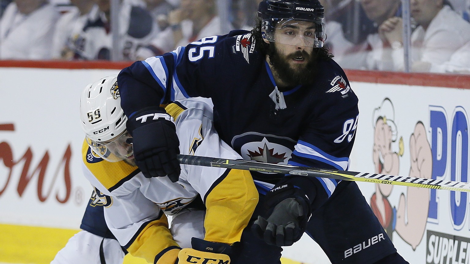 Nashville Predators&#039; Roman Josi (59) and Winnipeg Jets&#039; Mathieu Perreault (85) fight for the puck behind the Predators&#039; net during second period NHL hockey playoff action in Winnipeg, M ...