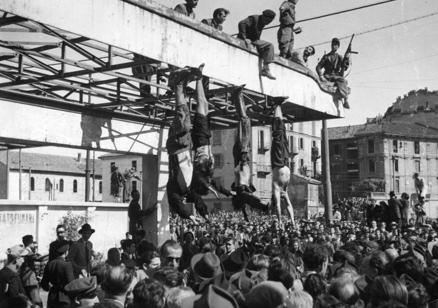 28th April 1945: The bodies of Benito Mussolini and Clara Petacci, his mistress, hang from the roof of a gasoline station after they had been shot by anti-Fascist forces while attempting to escape to  ...