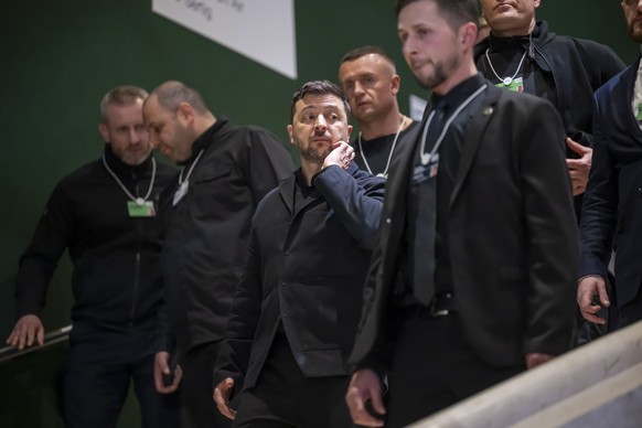 Ukraine's President Volodymyr Zelenskyy, center, leaves during the 56th annual meeting of the World Economic Forum, WEF, in Davos, Switzerland, Thursday, January 22, 2026. The meeting under the t ...