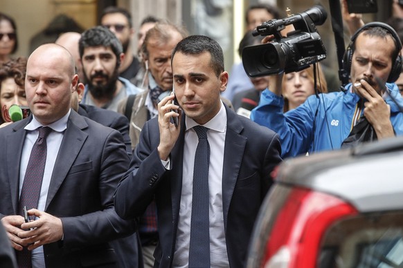 epa06744639 The Italian Five-Star Movement&#039;s (M5S) leader Luigi Di Maio (C) uses his mobile phone as he leaves the Lower House at the end of his meeting with &#039;League&#039; party leader Matte ...