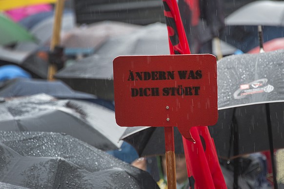 Demonstranten halten ein Schild hoch mit der Aufschrift &quot;aendern was dich stoert&quot; beim traditionellen 1. Mai-Umzug am Freitag, 1. Mai 2015, dem Tag der Arbeit, in Basel. (KEYSTONE/Georgios K ...