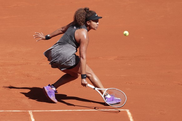 Naomi Osaka of Japan returns the ball to Karolina Muchova of the Czech Republic during their match at the Madrid Open tennis tournament in Madrid, Spain, Sunday, May 2, 2021. (AP Photo/Paul White)