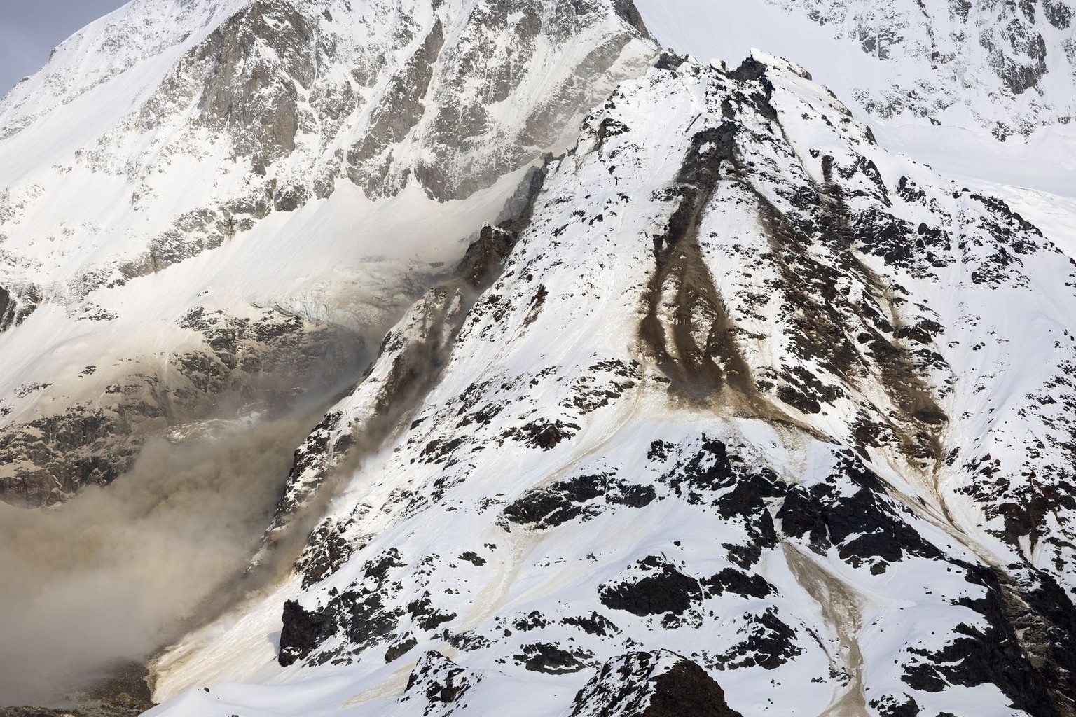 Felsen und Geroell von einem Felssturz liegen auf dem Birchgletscher, an einer Flanke des Berges Bietschhorn im Loetschental, am Montag, 19. Mai 2025, aufgenommen auf einer Alp ueber der Ortschaft Wil ...