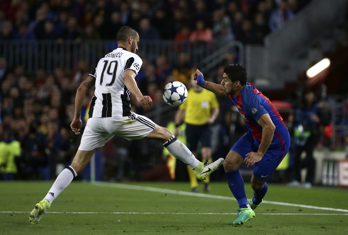 Juventus' Leonardo Bonucci, left, fights for the ball with Barcelona's Luis Suarez during the Champions League quarterfinal second leg soccer match between Barcelona and Juventus at Camp Nou ...