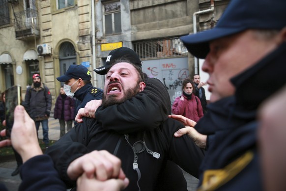 Police try to detain a protester on a street during a rally against the results of the parliamentary elections amid allegations that the vote was rigged in Tbilisi, Georgia, on Tuesday, Nov. 19, 2024. ...