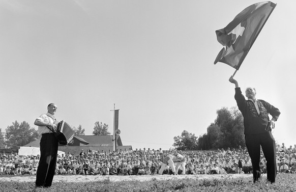 Begleitet von einem Schwyzerögelimusikanten tritt während den Kämpfen ein Fahnenschwinger auf (Aufnahme 1962).