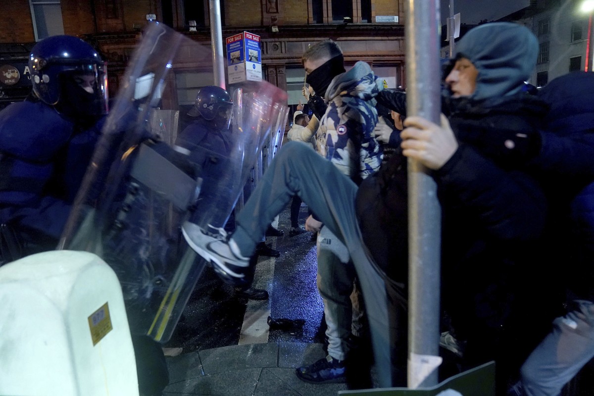Irish police officers form a line to block a demonstration near the scene of an attack in Dublin city center, Thursday Nov. 23, 2023. A 5-year-old girl is receiving emergency medical treatment in a Du ...