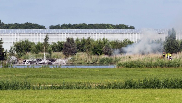 epa05353306 A view of the crash site of the A F-5 plane of Swiss stunt team Patrouille Suisse that crashed next to a greenhouse complex in Bitgum, The Netherlands, 09 June 2016. The pilot ejected hims ...