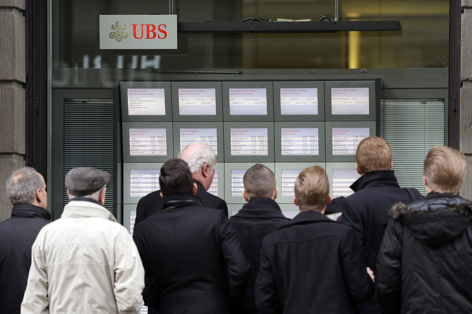 Vor der UBS an der Zürcher Bahnhofstrasse versammeln sich Menschen, um sich über die neuesten Aktien- und Devisenkurse zu informieren.