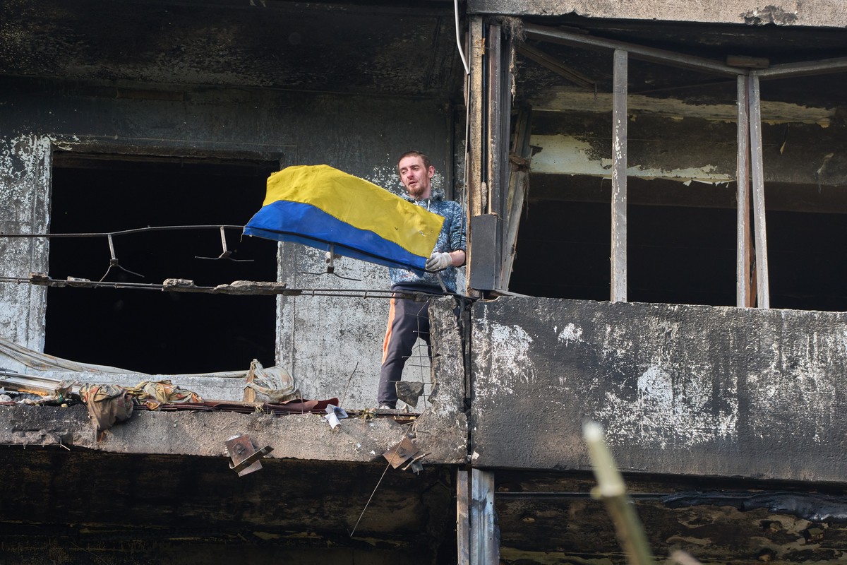 A man hangs out the national flag at his damaged apartment balcony after a missile strike during Russia's night air attack in Kyiv, Ukraine, Wednesday, Oct. 14, 2026. (AP Photo/Efrem Lukatsky)
Ru ...