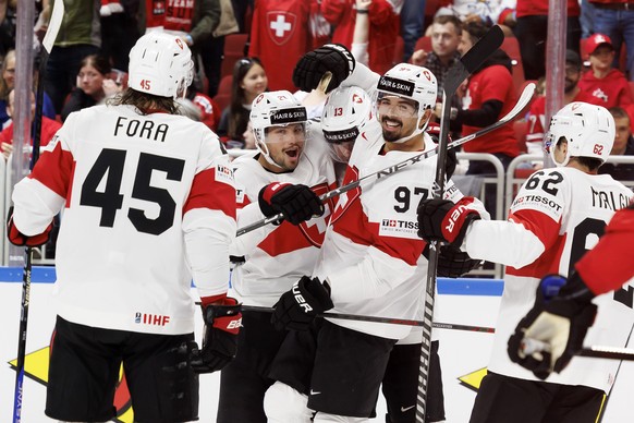 Swiss striker Nico Hischier #13 celebrates his goal with his teammates Swiss defender Michael Fora #45, Swiss striker Kevin Fiala #21, Swiss defender...