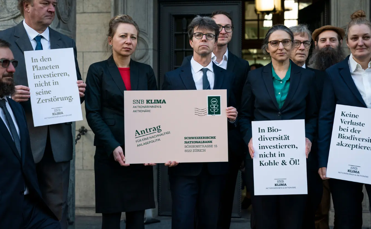 17 neue Kleinaktionärinnen und Kleinaktionäre der Nationalbank (SNB) übergeben symbolisch drei Anträge für eine forschere Klimapolitik vor dem Gebäude der Nationalbank an der Zürcher Börsenstrasse 15.