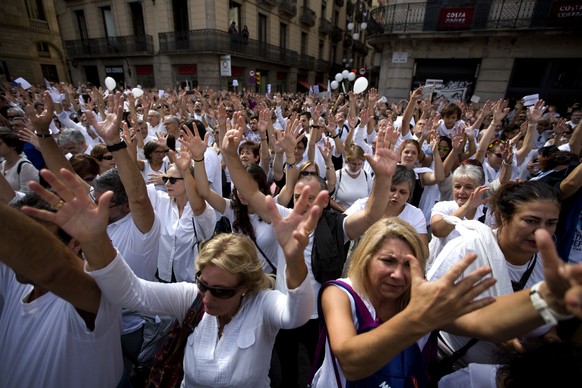 People raise their hands during a protest in favor of talks and dialogue in Sant Jaume square in Barcelona, Spain, Saturday Oct. 7, 2017. Thousands gathered at simultaneous rallies in Madrid and Barce ...