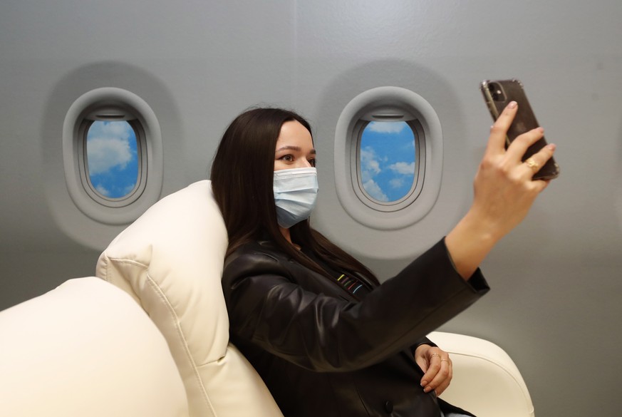 epa09154178 A model poses for a selfie in scenery resembling a luxurious interior of a busines airplane at a special Selfieroom in Zagreb, Croatia, 21 April 2021 (issued 23 April 2021). Zagreb, and th ...