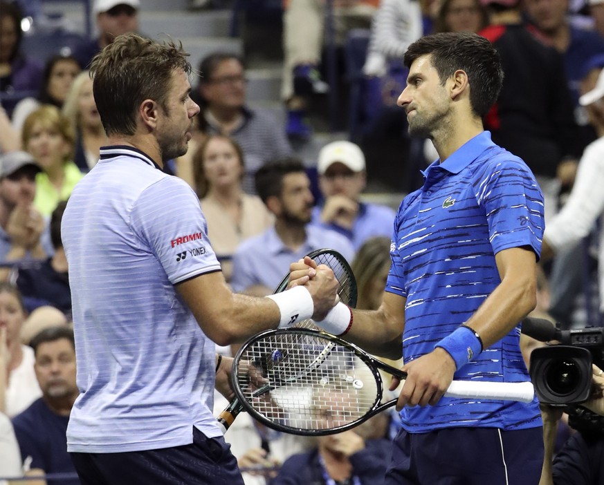 epa07811910 Stan Wawrinka of Switzerland (L) shakes hands with Novak Djokovic of Serbia (R) after he retires from the match in the third set on the seventh day of the US Open Tennis Championships at t ...
