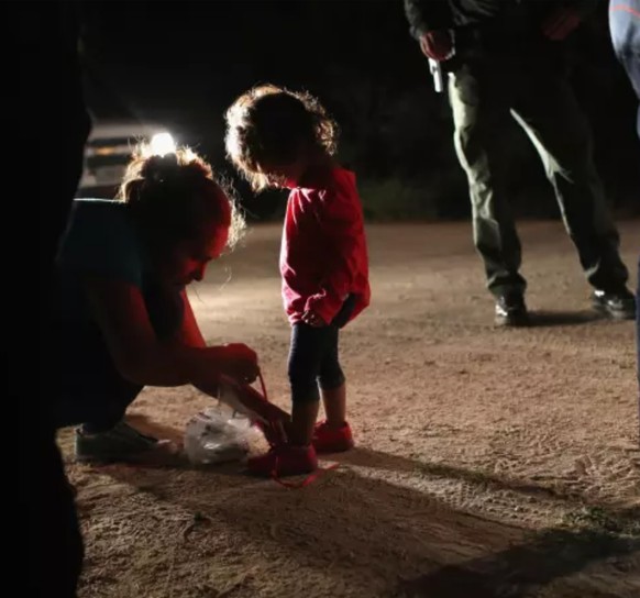 Kinder werden ihren Müttern entrissen: 7 Fakten über die Situation an der US-Grenze
Dieses Bild der Mutter, die ihrem Kind auf Geheiß der Grenzwächter die Schuhnesteln entfernen muss bevor beide in ei ...