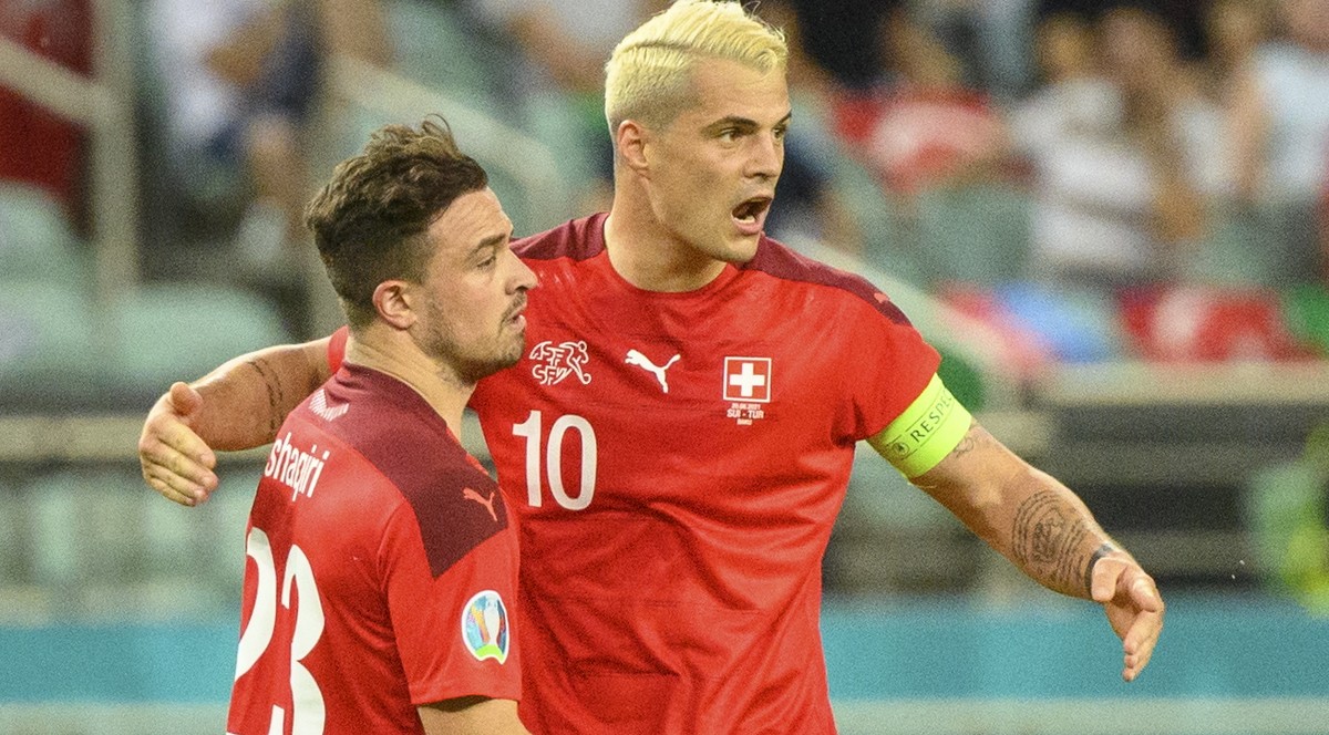 epa09288931 Switzerland's midfielder Xherdan Shaqiri (L) celebrates the second goal with Switzerland's midfielder Granit Xhaka during the UEFA EURO 2020 group A preliminary round soccer matc ...