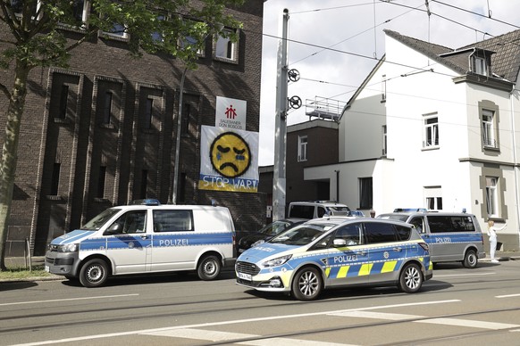 Police vehicles are parked in front of the Don Bosco High School in Essen, Germany, Thursday, May 12, 2022. Police in the western German city of Essen seized weapons from the apartment of a 16-year-ol ...