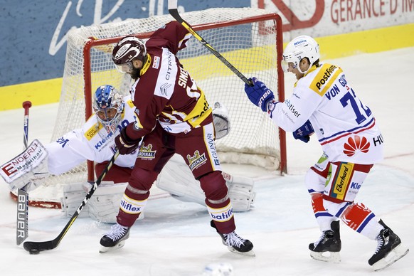 Kloten&#039;s goaltender Luca Boltshauser, left, vies for the puck with Geneve-Servette&#039;s forward Juraj Simek, center, past Kloten&#039;s defender Patrick Von Gunten, right, during a National Lea ...